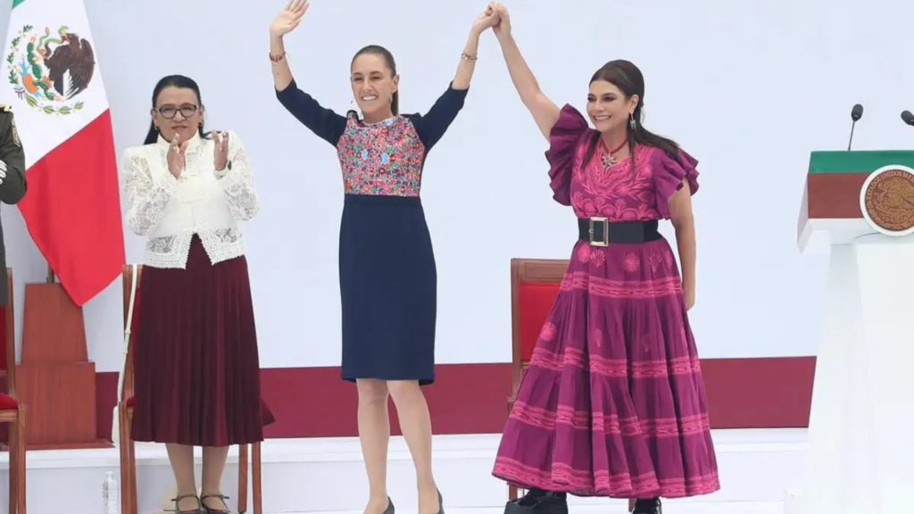 Claudia Sheinbaum y Clara Brugada levantan las manos durante un acto en el Zócalo