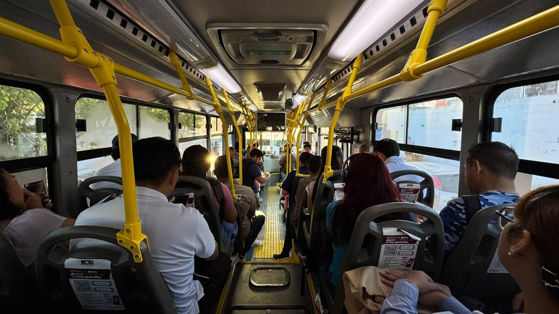 Usuarios viajan en una unidad de MOBI antes del inicio del esquema regular de cobro de la Ruta 27 en Cancún.