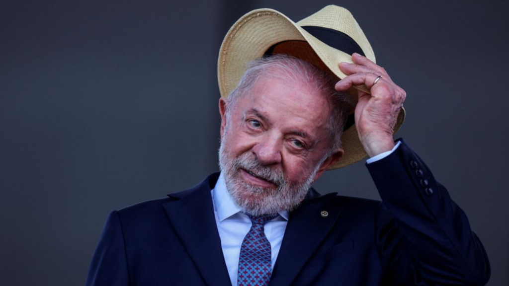 Luiz Inácio Lula da Silva saluda levantando un sombrero durante un acto público.