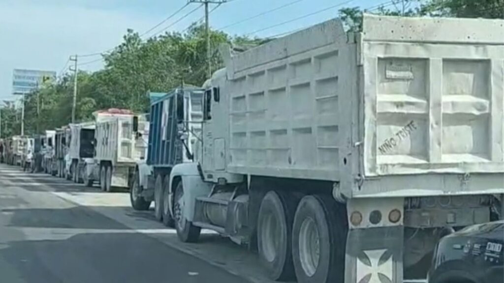 Camión de volteo gris circulando por una vialidad de Cancún, Quintana Roo