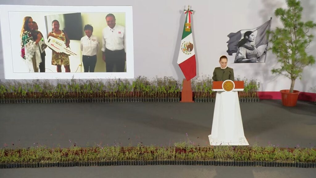 Claudia Sheinbaum durante La Mañanera, con una pantalla que muestra la entrega de viviendas del Infonavit en Quintana Roo.
