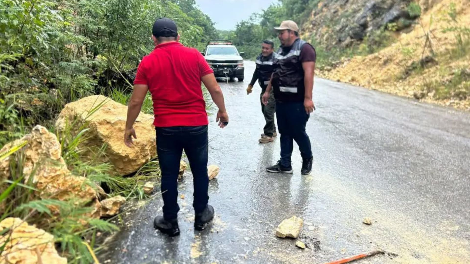 Enorme roca desprendida junto a una camioneta y trabajadores de Protección Civil tras el deslave en Othón P. Blanco.