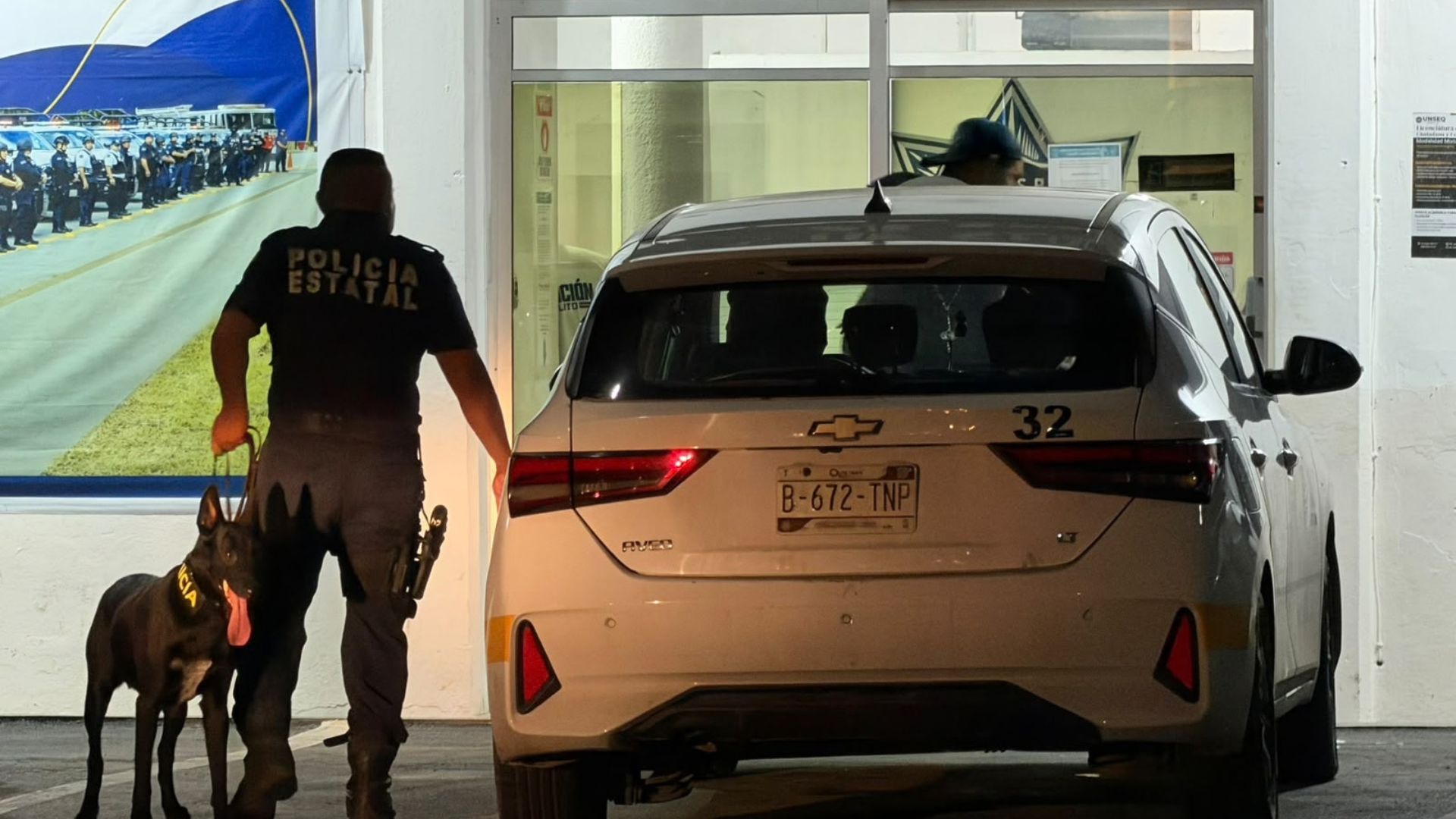 Elemento policial junto a un taxi durante la detención de una pareja por presunto robo en Felipe Carrillo Puerto