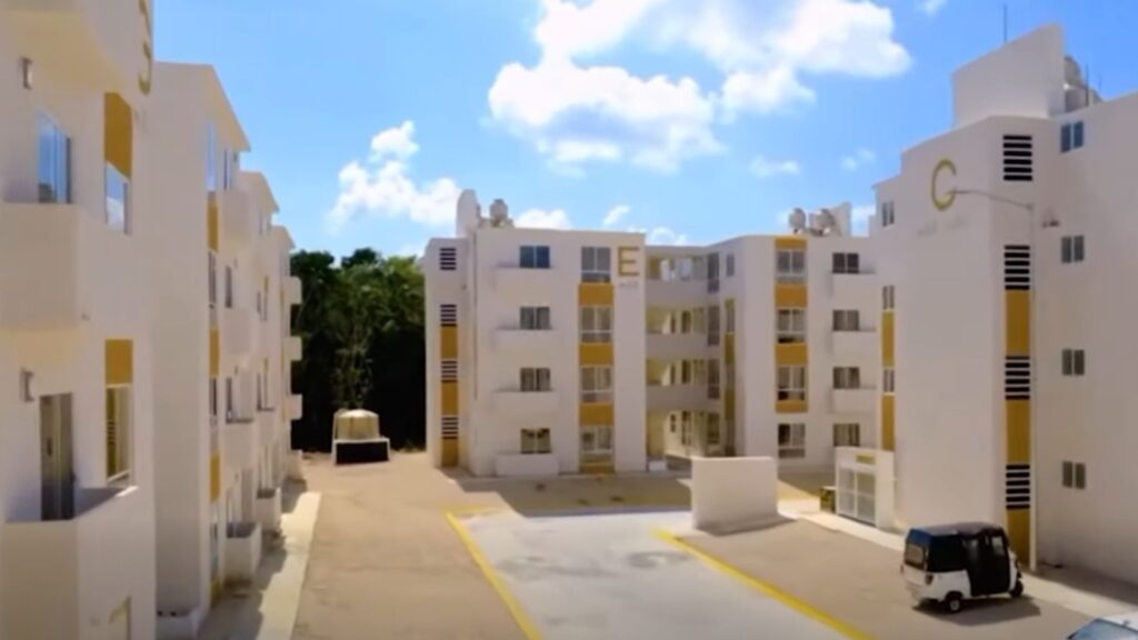 Edificios de departamentos blancos con detalles amarillos en el fraccionamiento Infonavit-Puerto Maya de Playa del Carmen.